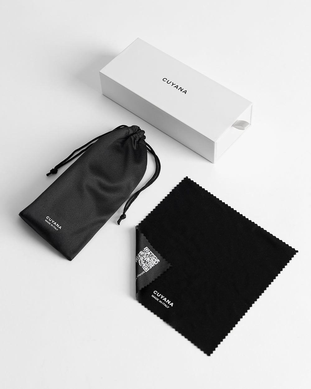 Brisa Sunglasses Box, drawstring pouch, and cloth on a surface.