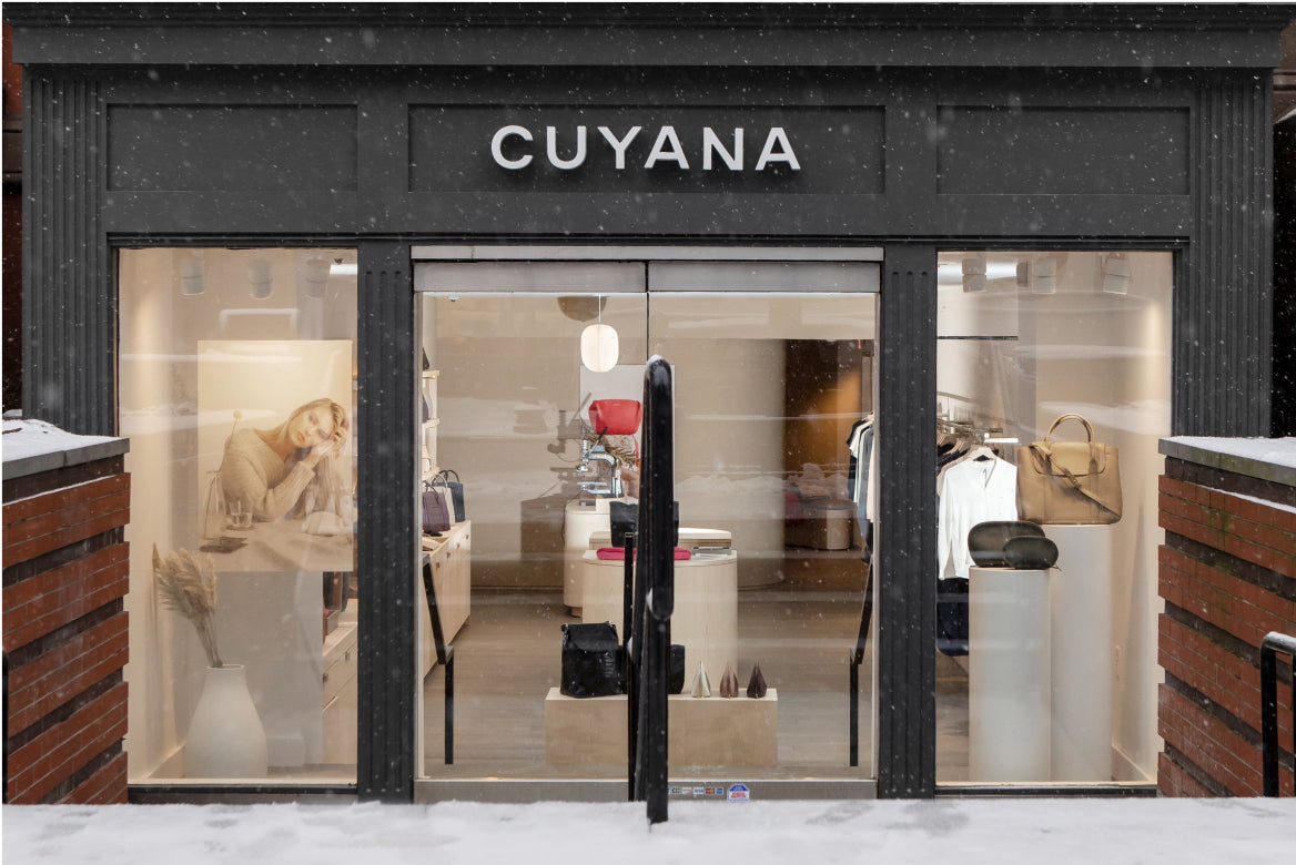 Storefront of Vellors with visible interior including displayed bags and two mannequins.