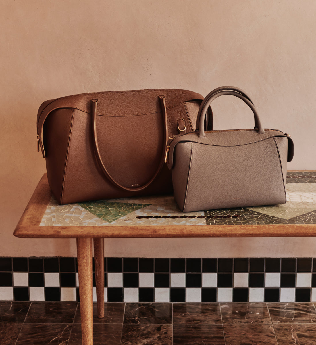 Two handbags on a patterned table.