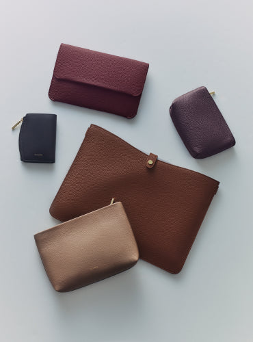 Assorted leather pouches and wallets arranged on a surface