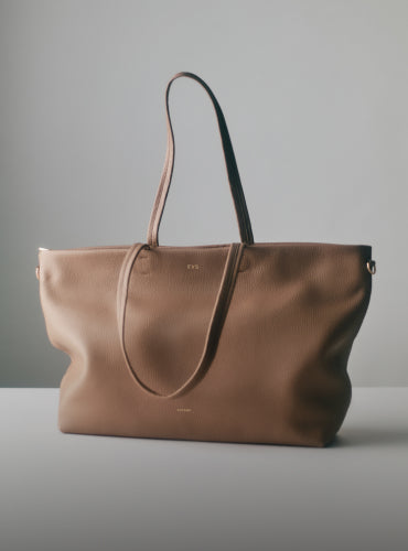 Tote bag with two handles on a plain surface.
