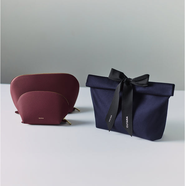 Two pouches, one tied with a ribbon, on a surface.