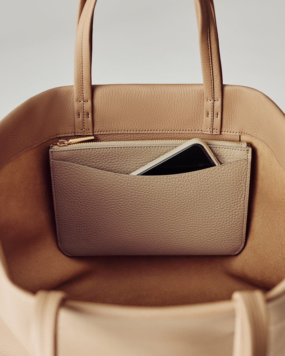 Open handbag with a pouch and a smartphone inside.