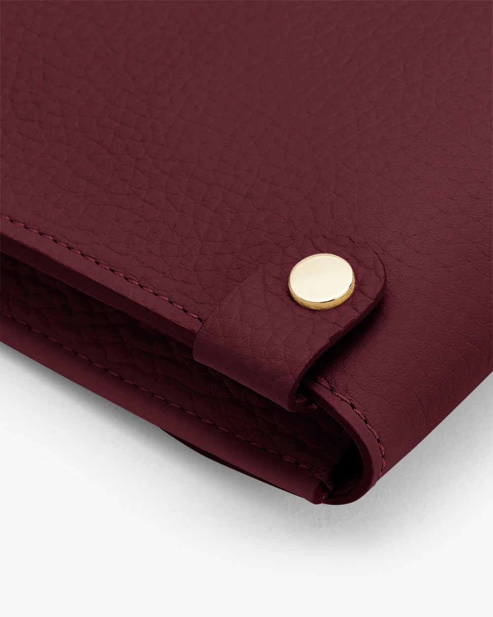 Close-up of a folded corner of a textured leather item with a button.