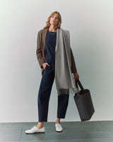 Person in suit with a scarf and a large tote bag.
