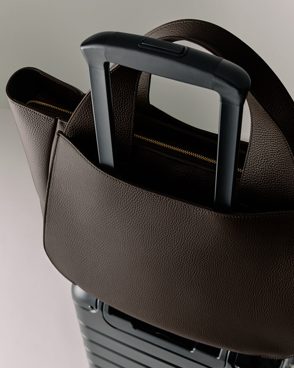 Luggage handle with a bag looped over it
