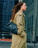 Person walking in the city wearing handbag over shoulder with a metal chain strap