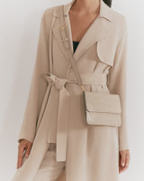 Woman wearing a trench coat with a crossbody bag