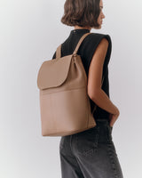 Person wearing sleeveless top and wearing a backpack.