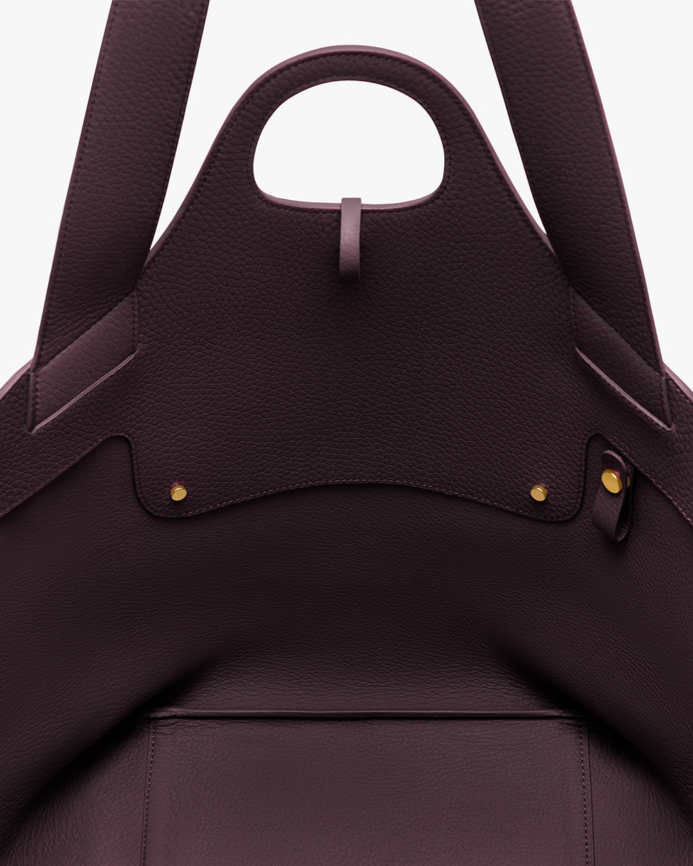 Close-up of an open handbag with visible stitching and metal studs.