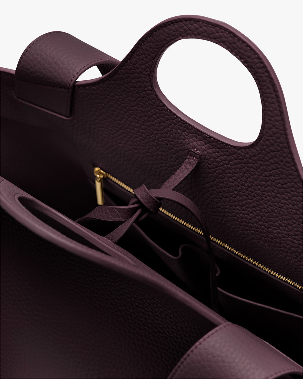 Open handbag showing handle and zippered pocket inside