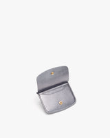 Open small wallet with snap fastener on a plain background.