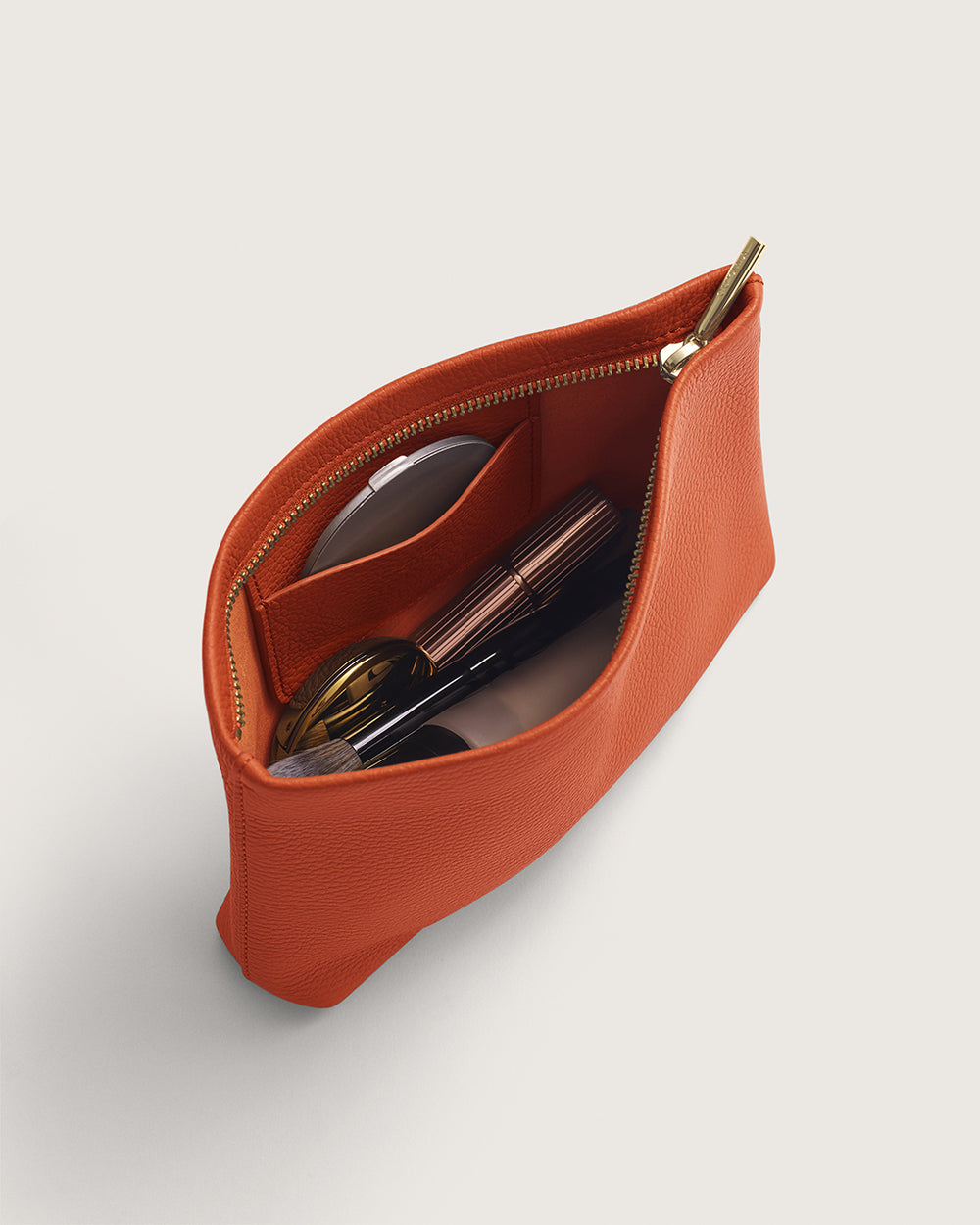 Open pouch with zipper containing sunglasses and two small items inside.