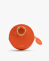 Round coin pouch with a gold ring detail and zipper closure.