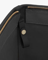 Open handbag with gold zipper and interior compartment.