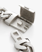 Close-up of an open metal clasp linked to a chain.