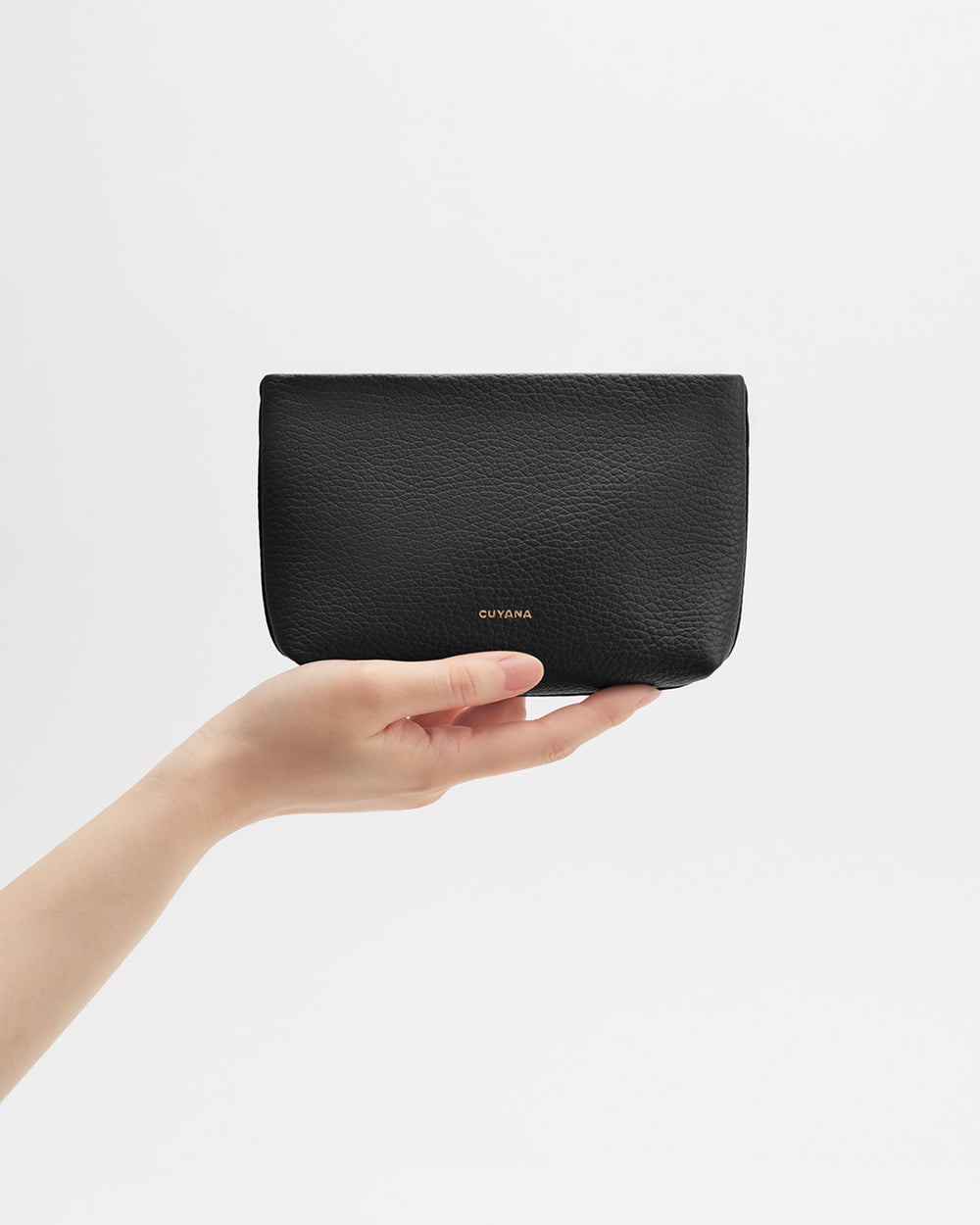 Hand holding a small wallet with text branding.