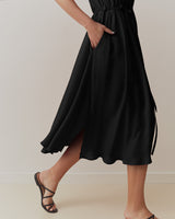 Person wearing a mid-length skirt and heels, walking.