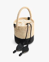 Woven bucket bag with drawstring closure and decorative tassels.