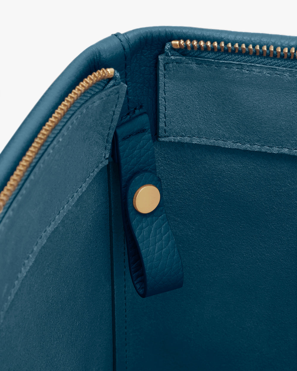 Close-up of leather bag interior with zipper and button.