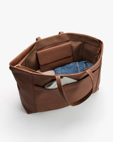 Open travel bag with a wallet, denim fabric, and white item inside