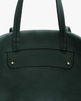 Close-up of tote bag top section with handles and two small studs.