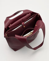 Open handbag with visible compartments and contents inside.