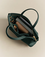 Open handbag with items like a wallet, book, and a phone inside