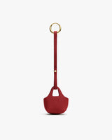 Small textured keychain bag with handle and gold ring.