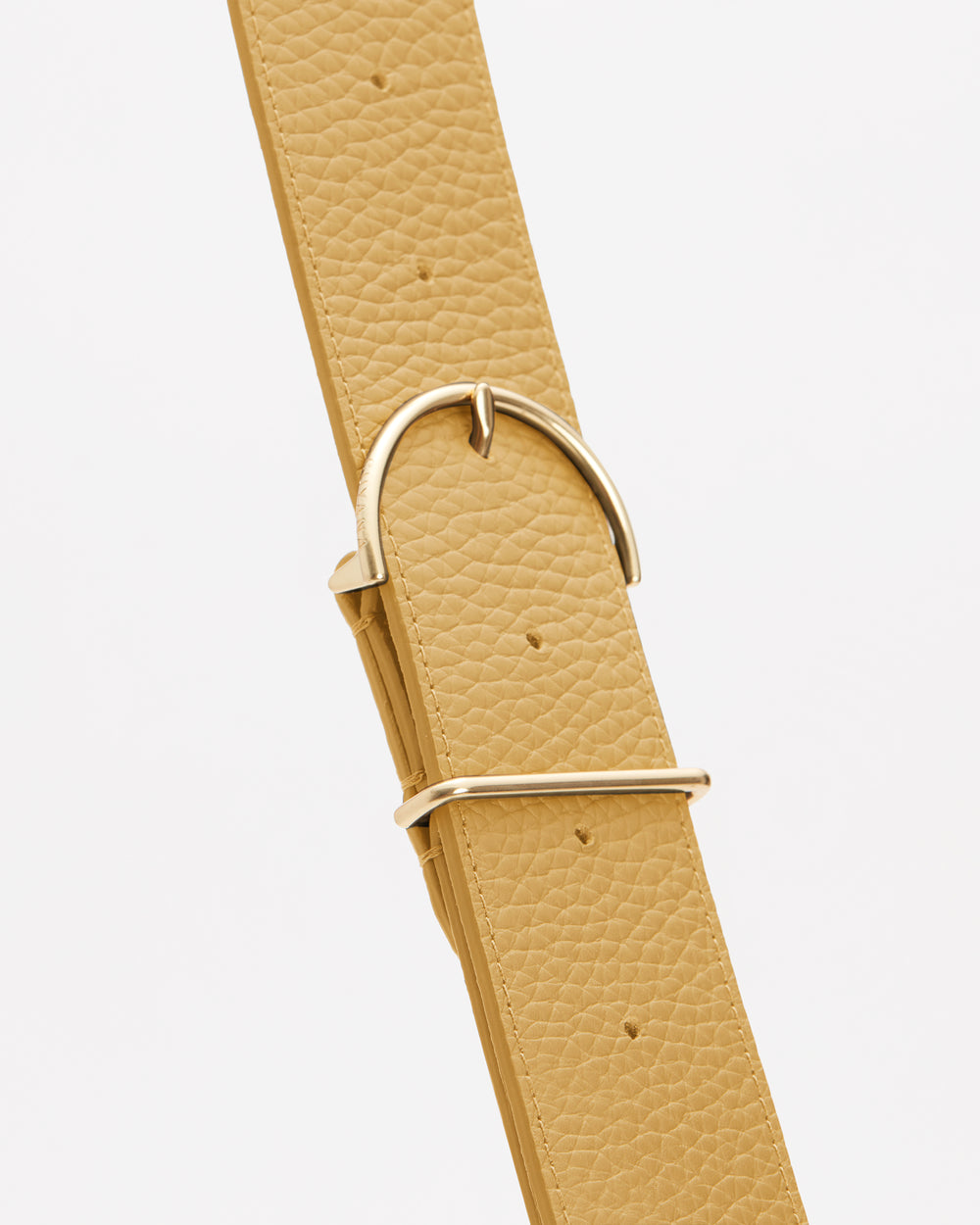 Close-up of a textured belt with a metal buckle.