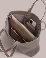 Open tote bag with pouches, wallet, and phone inside.
