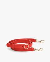 Adjustable bag strap with clasps on both ends for attaching to a handbag.