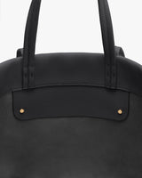 Close-up of a travel bag with two handles and small metal accents.