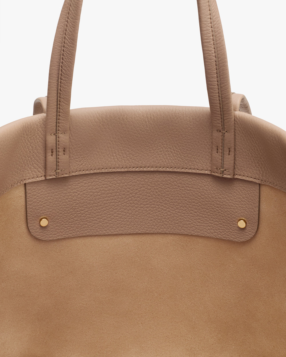 Close-up of a bag with dual handles and rivet details.