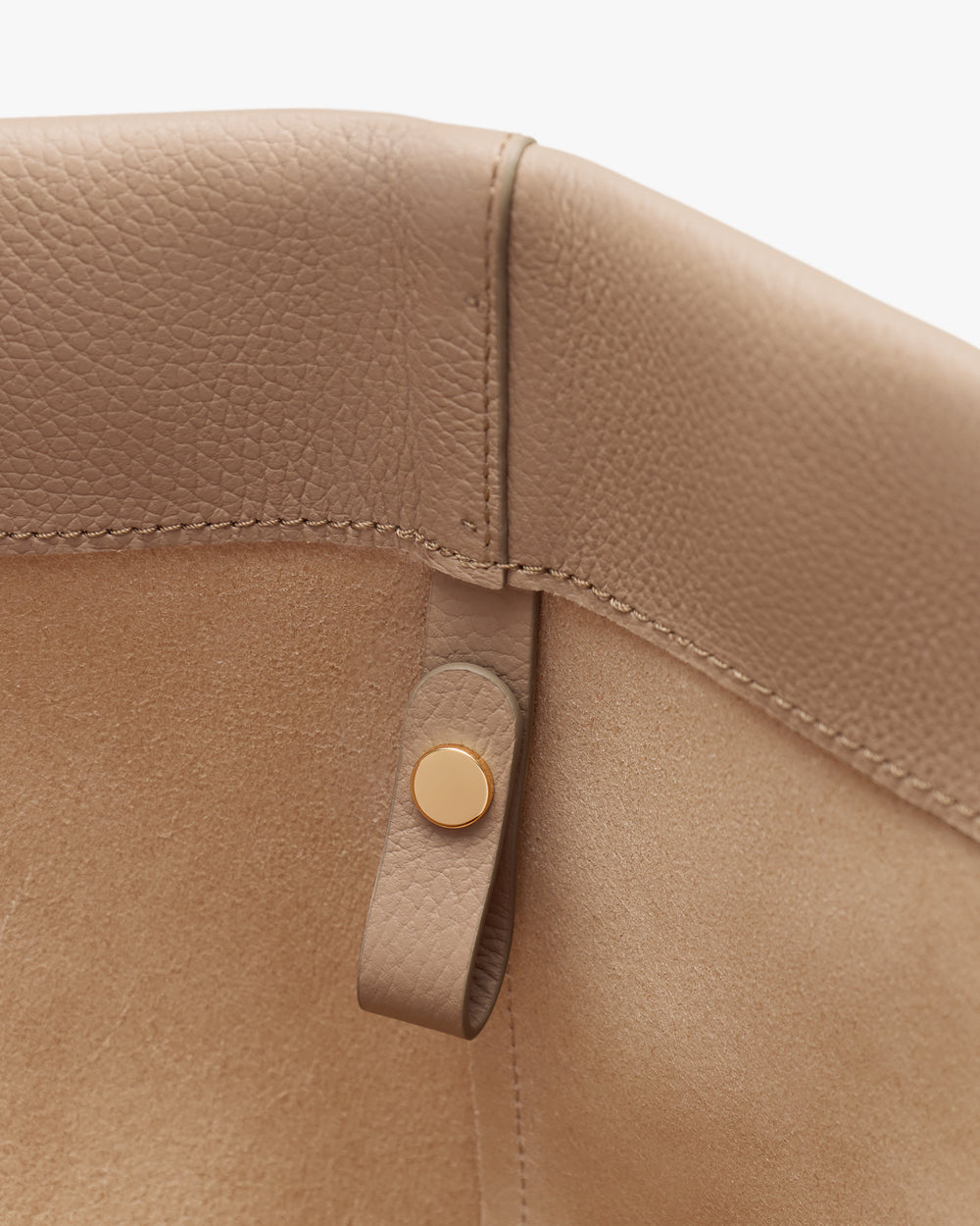 Close-up view of a leather bag corner with a button detail.