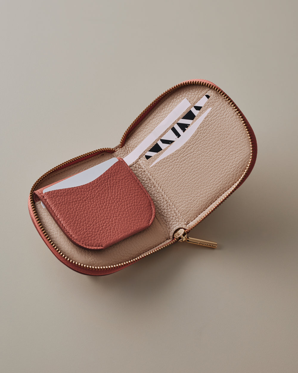 Open zippered wallet with card slots and a card inside.