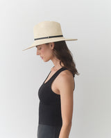 Person wearing wide-brimmed hat and sleeveless top, facing left.