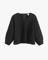 Loose-fit long-sleeve top with a round neckline on a white background.