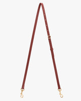 Leather strap with metal clasps and adjustable buckle on white background.