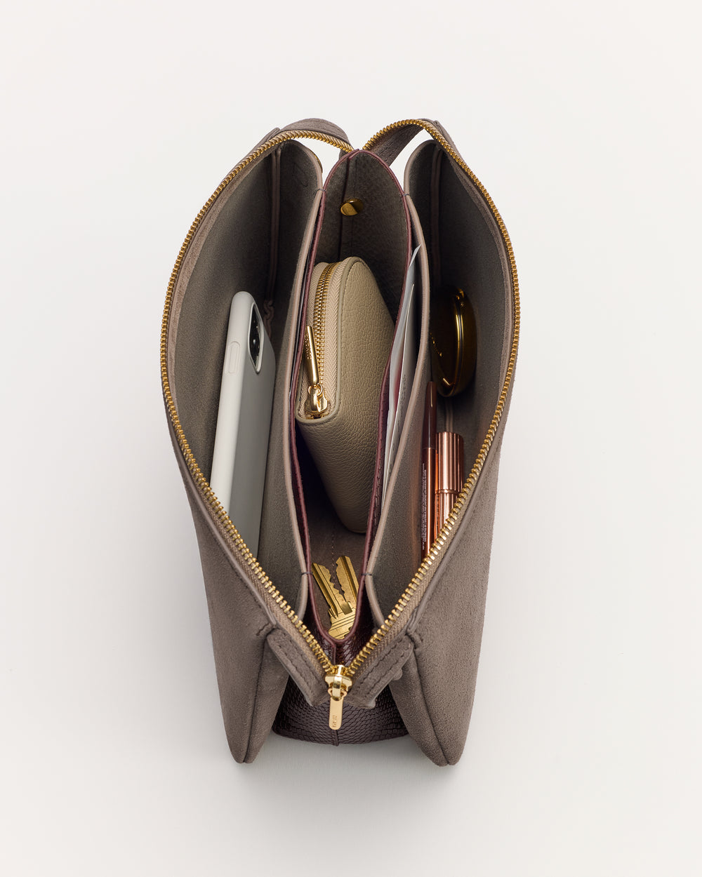 Open handbag with phone, small purse, and various items inside.