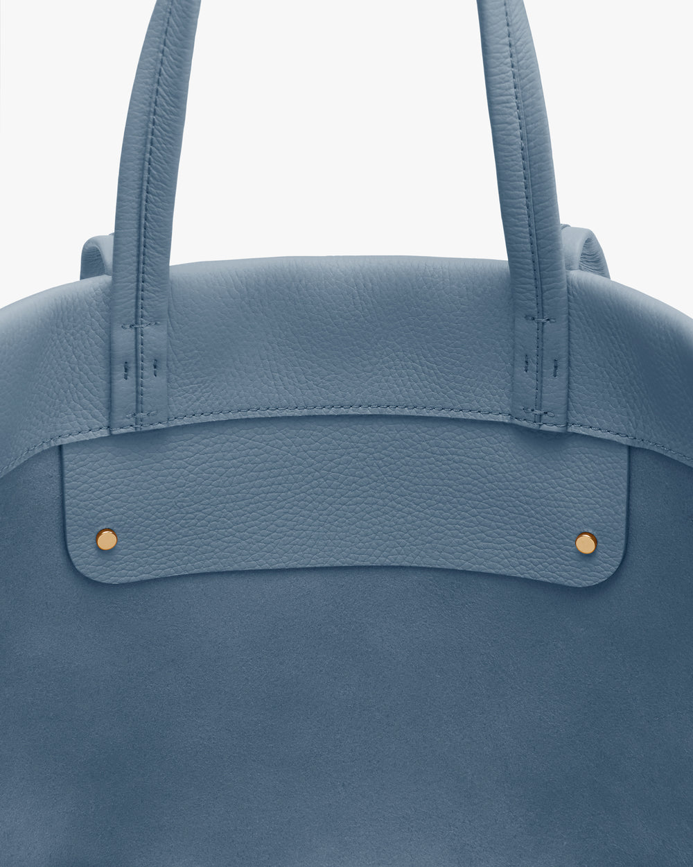 Close-up of a travel bag with two handles and metal studs.