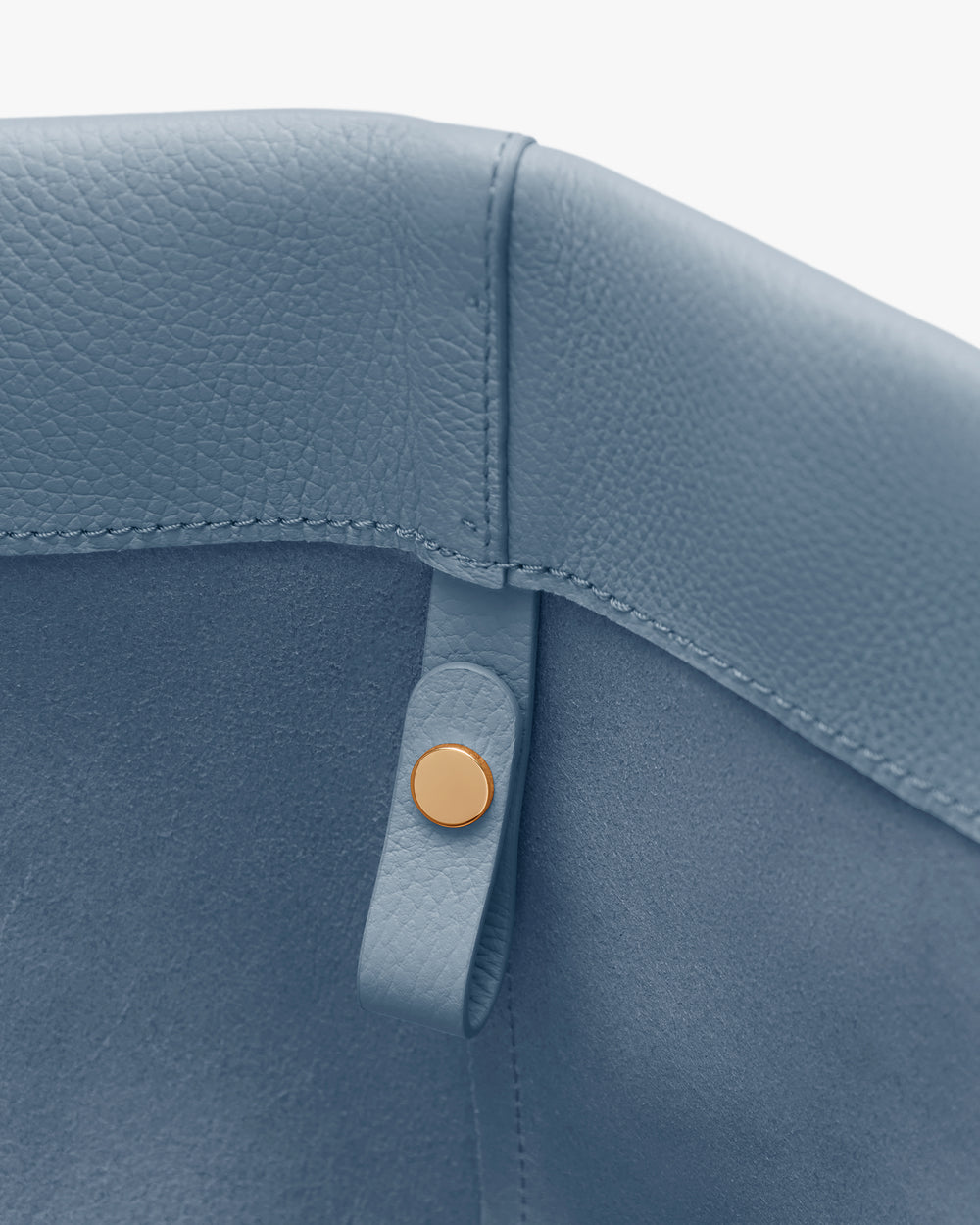 Close-up of a bag's interior stitching and button detail.