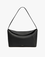 A handbag with a curved shape and single strap.