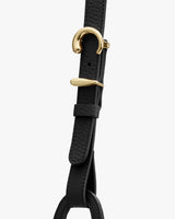 Close-up of a strap with gold metal buckle and textured leather detail