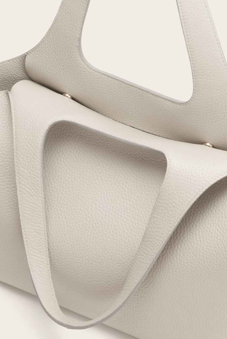 Close-up of a structured handbag with visible handles and pockets.