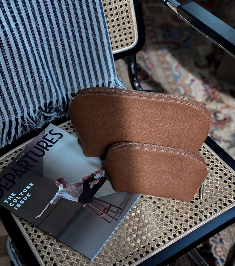 Two pouches on a magazine beside a chair with a striped cushion.