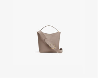 A handbag with a strap and handle on a plain background.