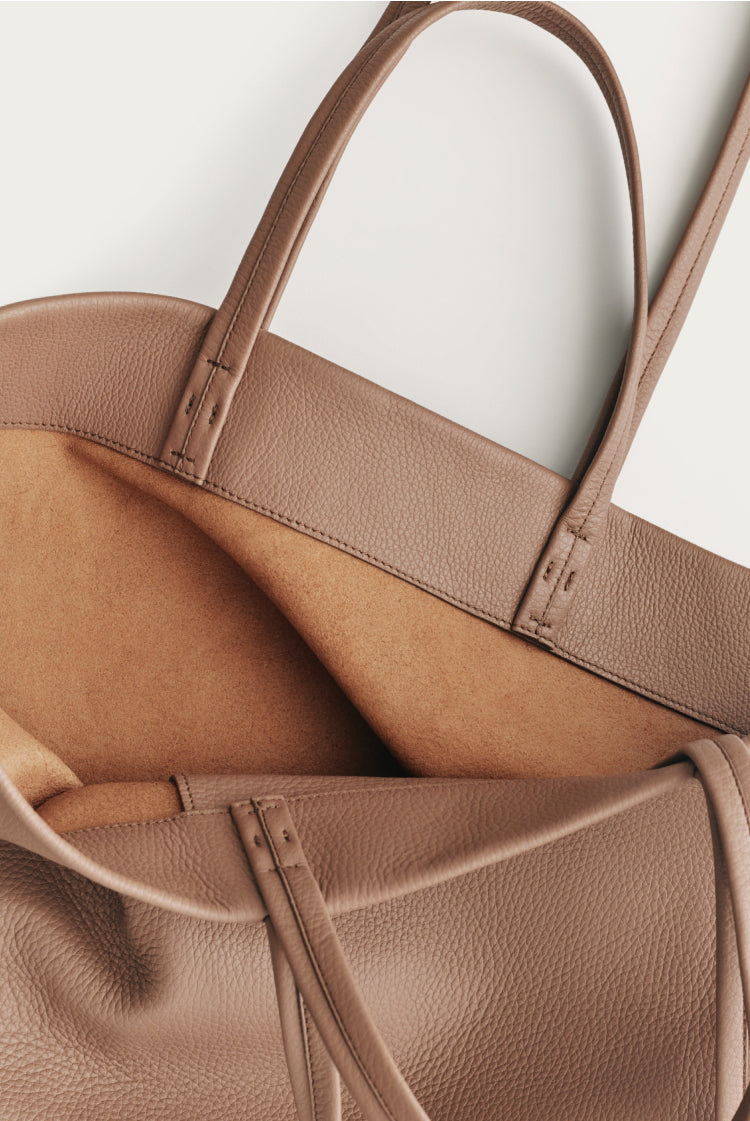 Close-up of two overlapping handbags with visible handles and stitching.