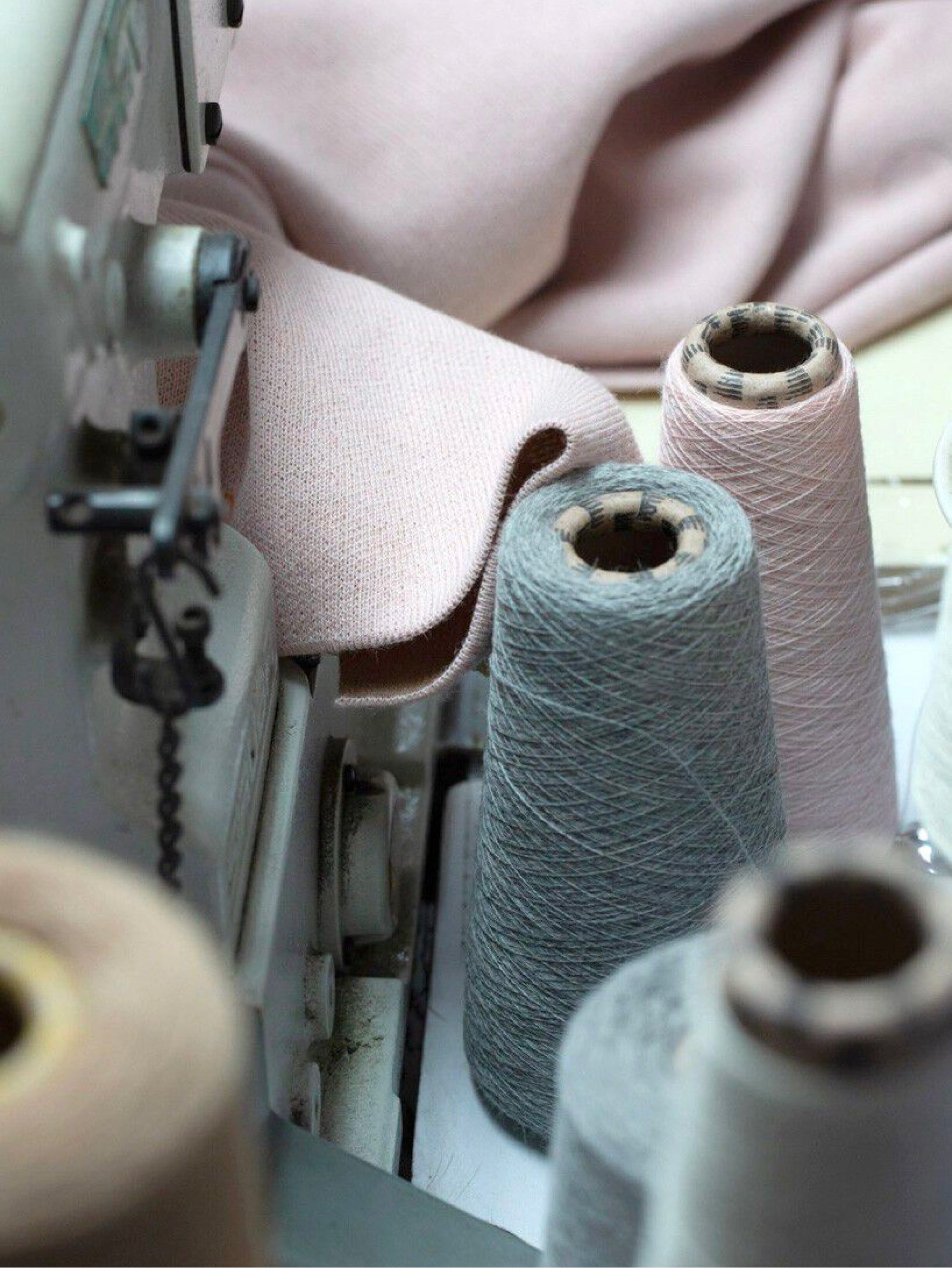 Sewing machine with several thread spools and fabric.
