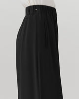 Person wearing long pants with an elastic waistband and side pockets.